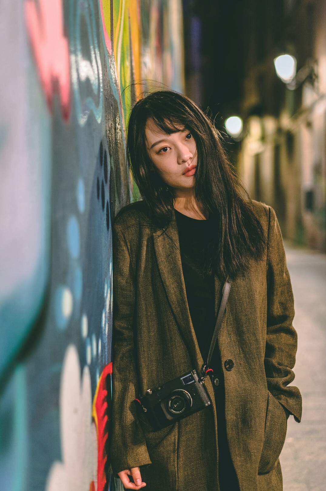Portrait of a young woman street photographer holding a camera